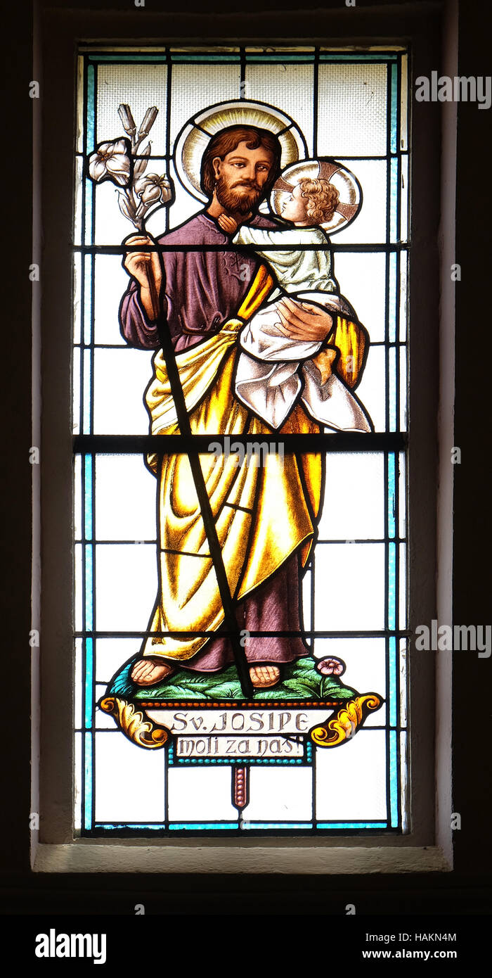 Saint Joseph tenant l'enfant Jésus, vitrail dans l'église paroissiale de la Sainte Trinité de Krasic, Croatie Banque D'Images