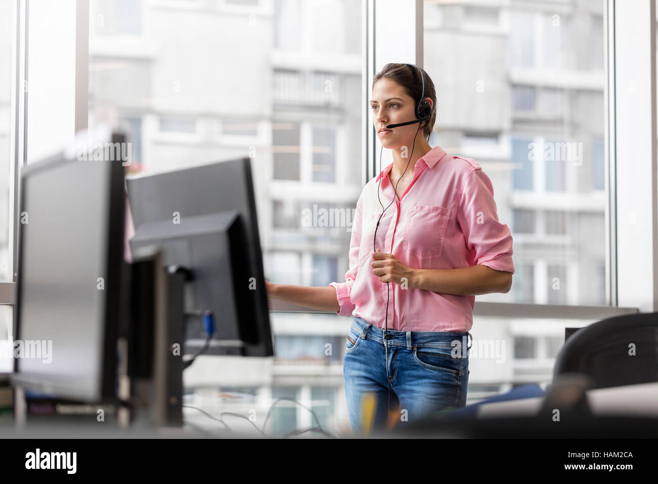 Businesswoman talking on téléphone à l'aide d'appareil mains libres in office Banque D'Images