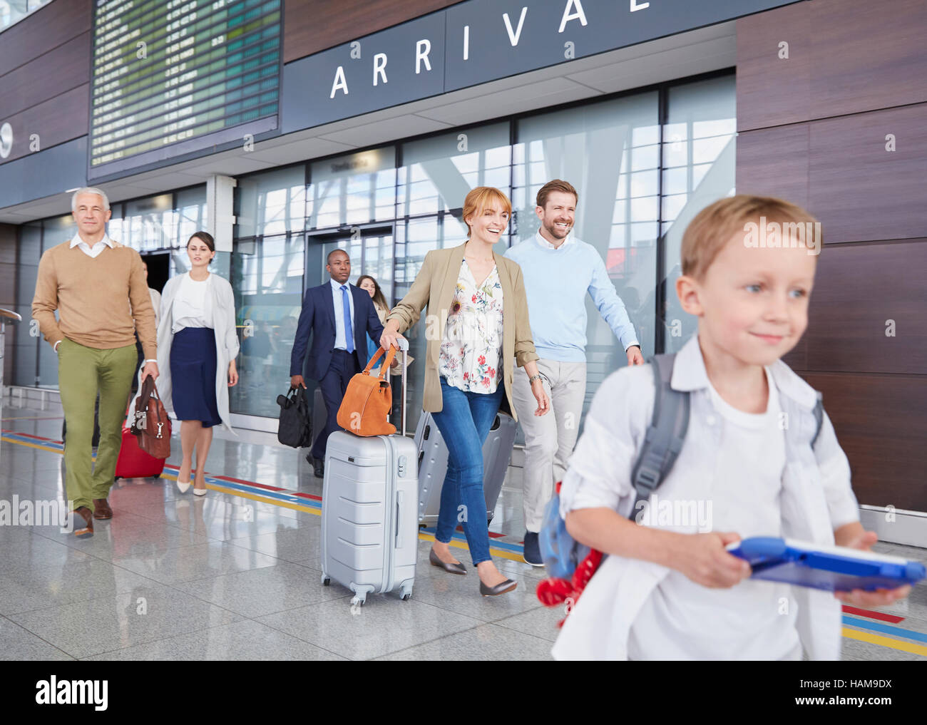 Les voyageurs avec valises walking in airport concourse Banque D'Images