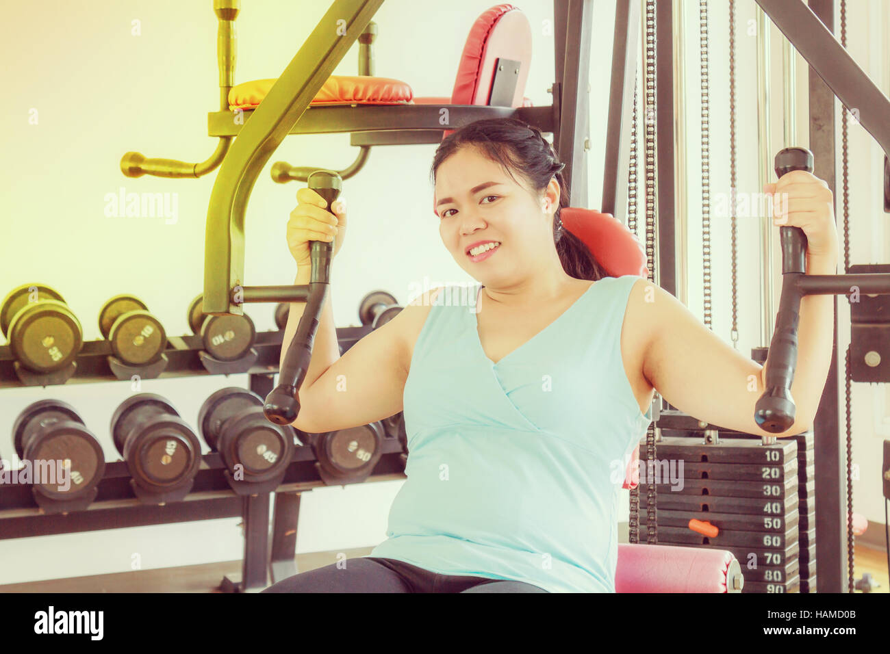 Asie grosse femme bras formation équipement dans la salle de sport pour la force, la perte de poids. Banque D'Images