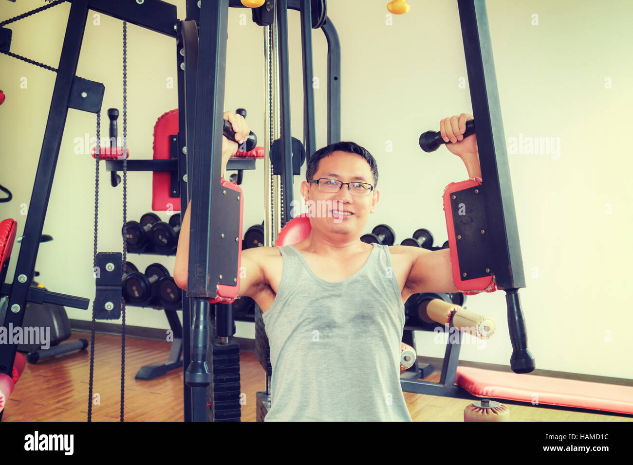 L'homme en Asie formation d'âge moyen de l'équipement du bras dans la salle de sport pour la force, la perte de poids. Banque D'Images