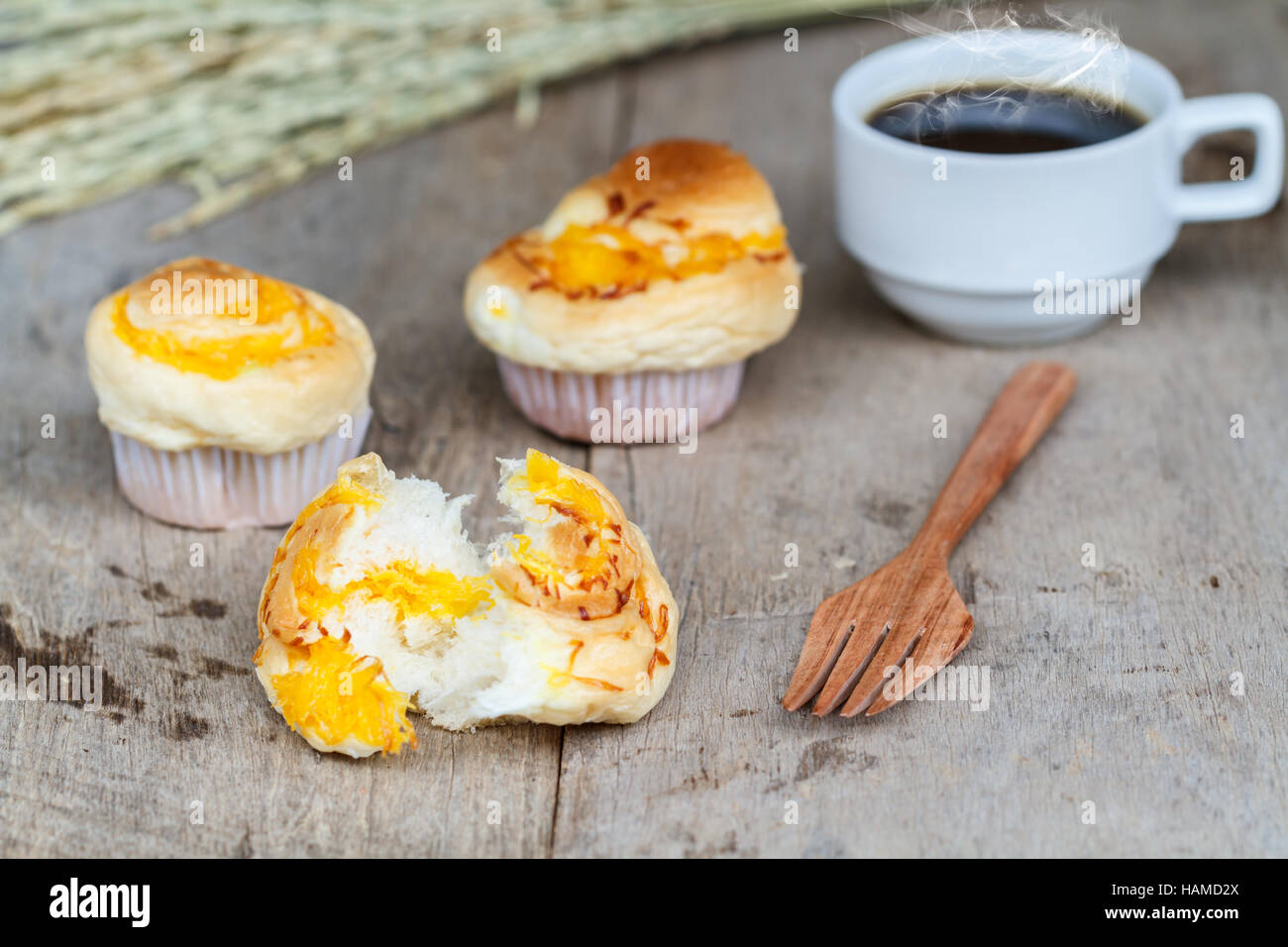 Fils d'or Muffin avec fourche en bois et du café noir sur la table en bois. Dessert thaïlandais appeler Foi Thong. Banque D'Images