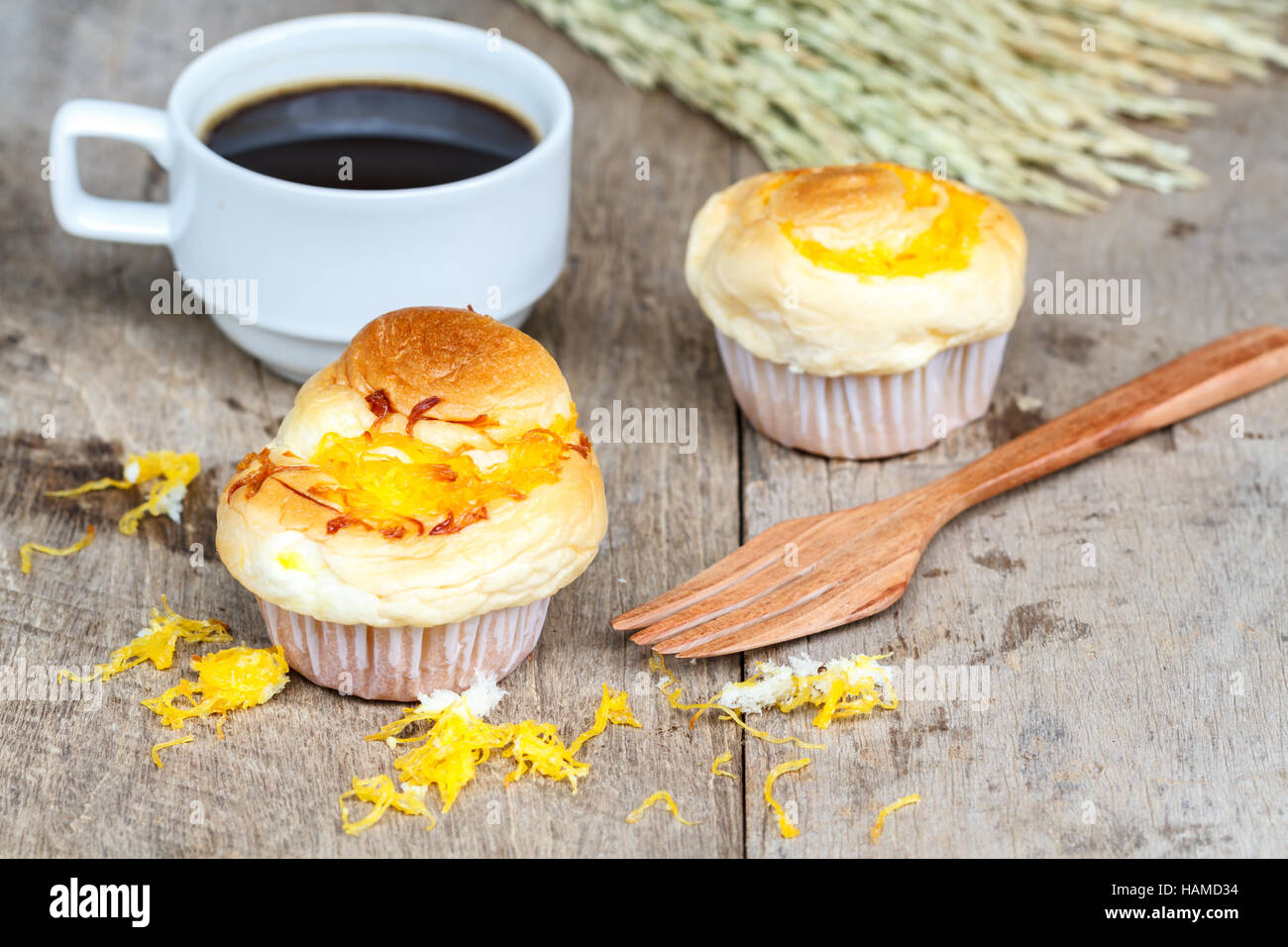 Fils d'or Muffin avec fourche en bois et du café noir sur la table en bois. Dessert thaïlandais appeler Foi Thong. Banque D'Images