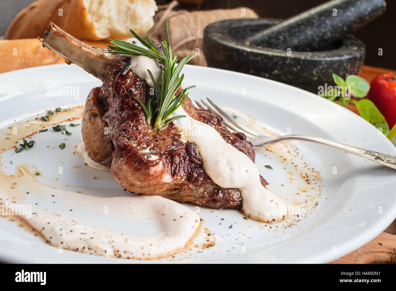 Concept : Les menus de restaurant, d'une saine alimentation, faits maison, gourmands, la gourmandise. Plaque blanche de rack d'agneau sur table en bois et d'ingrédients sur l'arrière-plan. Banque D'Images