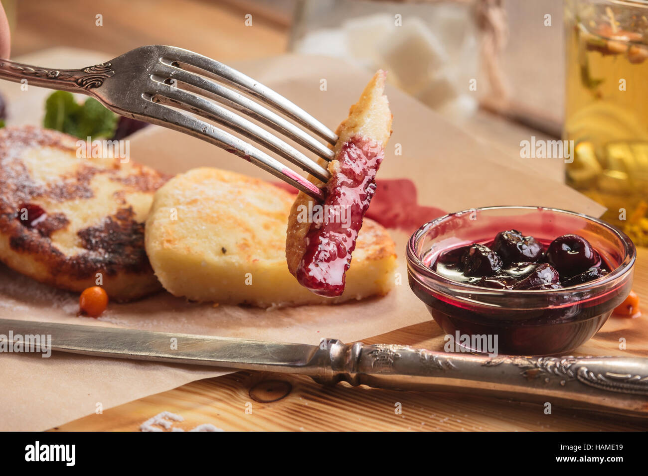 Concept : Les menus de restaurant, d'une saine alimentation, faits maison, gourmands, la gourmandise. Crêpes au fromage servi avec la sauce aux cerises sur le papier avec des ingrédients sur vintag Banque D'Images