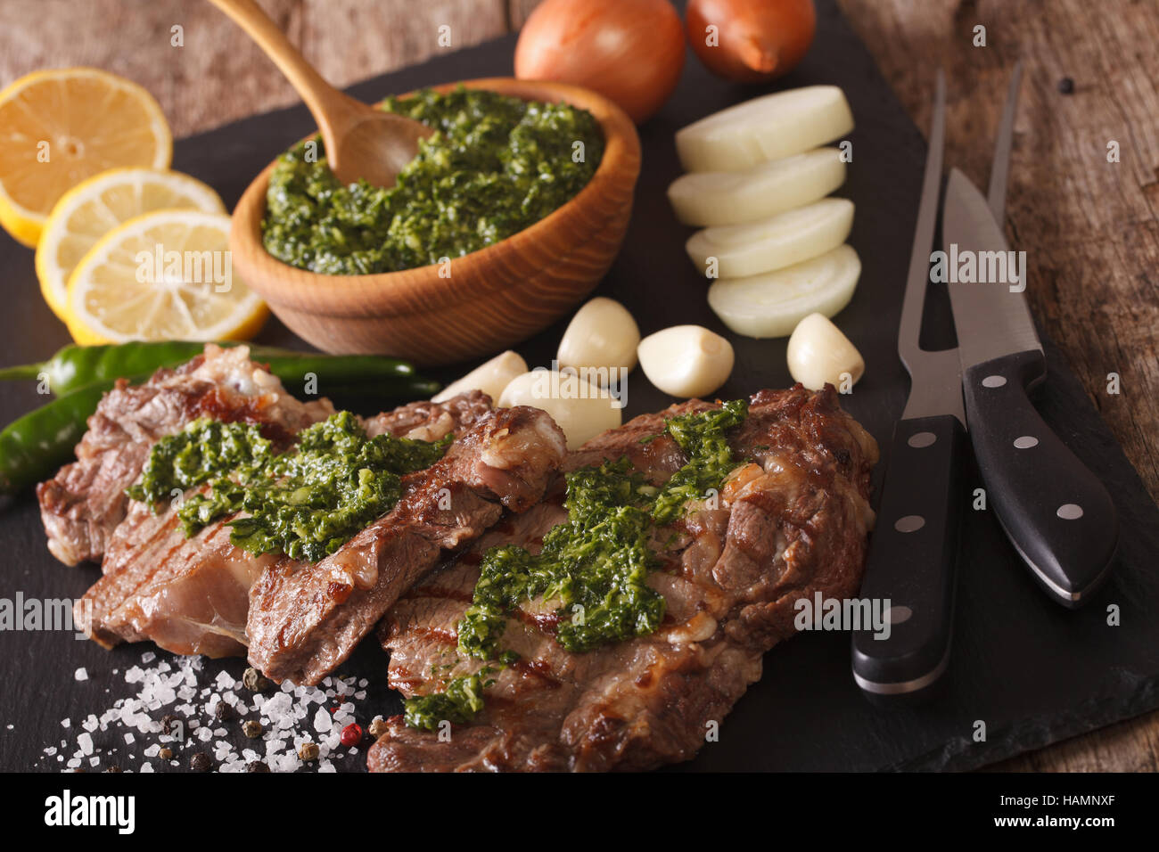 Délicieux steak de boeuf grillée avec sauce Chimichurri close-up sur la table horizontale. Banque D'Images