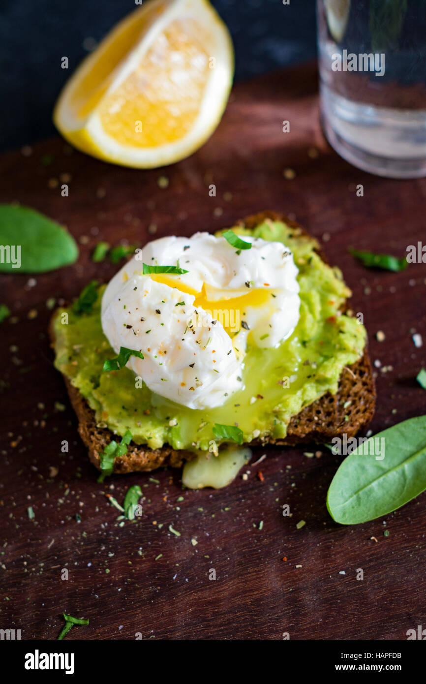 La purée d'avocat et œuf poché sur pain de seigle grillé. Un petit-déjeuner sain, collation santé Banque D'Images