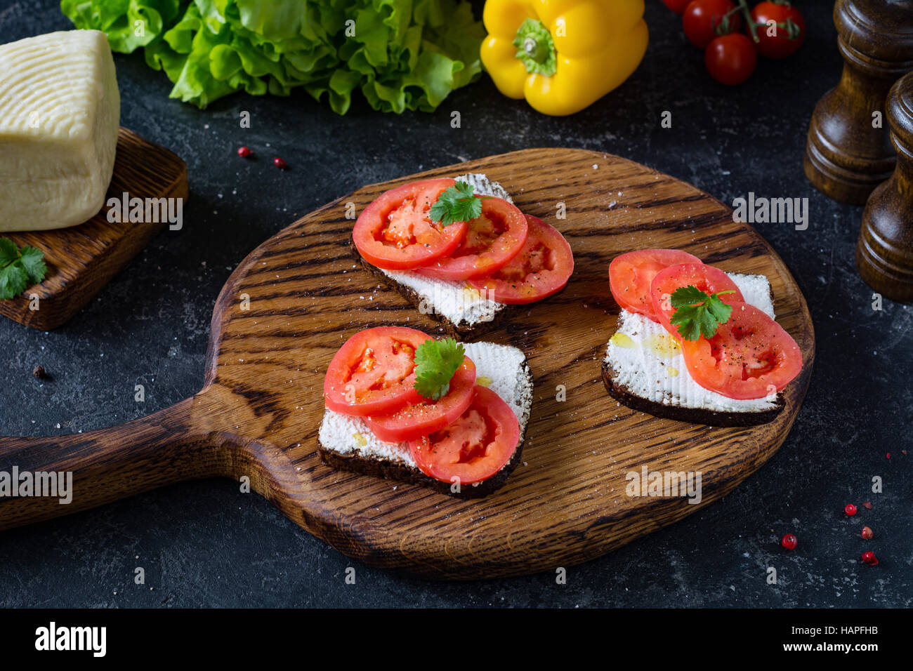 Sandwich sain avec de la ricotta, tomates et le persil sur le pain de seigle à grains entiers. Vue de côté, l'accent avant Banque D'Images