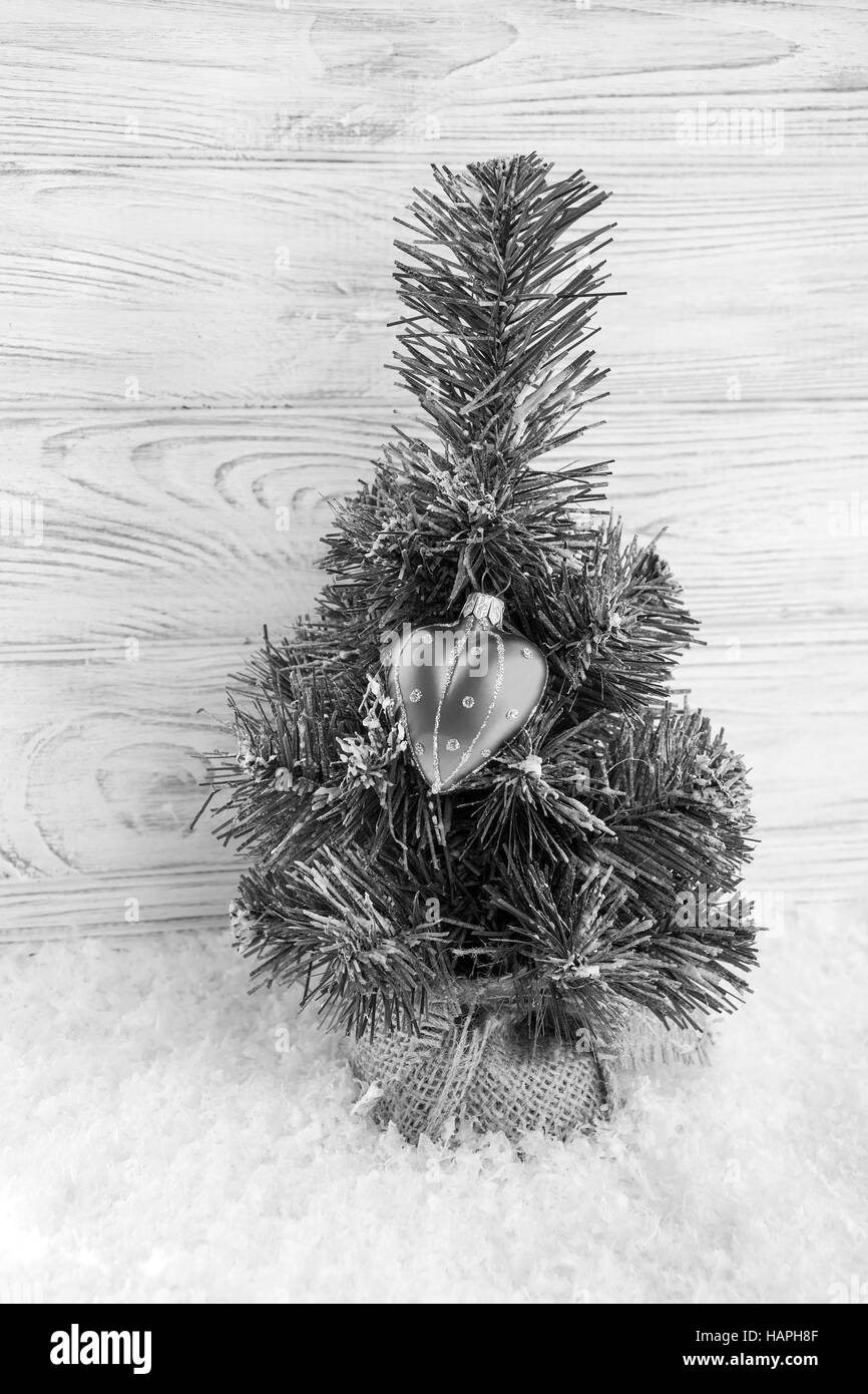 Arbre de Noël, la neige et le coeur décoration avec fond de bois derrière. Fond de carte de vœux. Vintage noir et blanc Banque D'Images