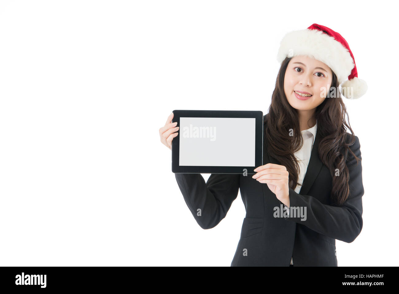 Affaires Noël woman holding digital tablet in santa hat. Businesswoman showing pad avec écran Copier l'espace pour la publicité. Modèle féminin asiatique je Banque D'Images