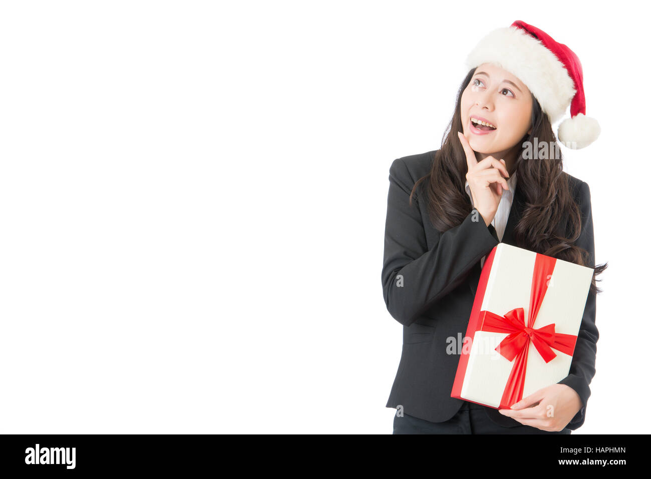 Femme d'affaires de Noël montrant copie espace pointant vers le haut pour le côté d'être heureux et surpris. Isolé sur fond blanc. Young smiling woman in Banque D'Images
