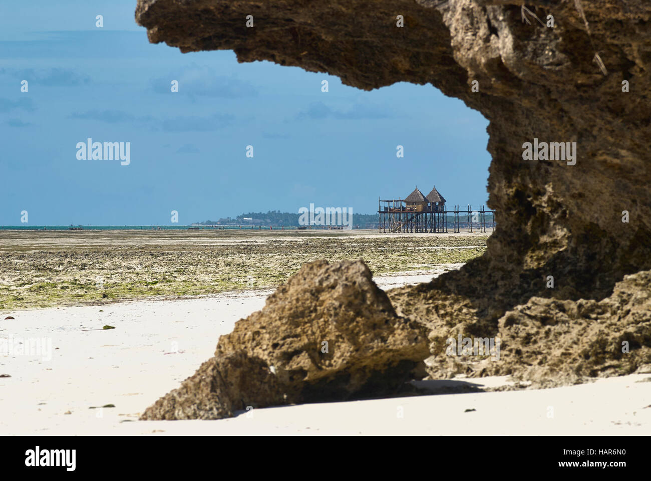 Vue de la plage par une falaise de roche de corail avec une jetée et d'un restaurant sur les poteaux Banque D'Images