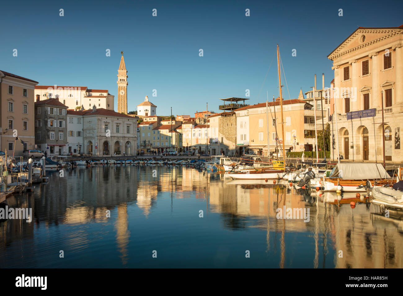 La lumière du soleil du soir sur la Marina, flèche de l'église paroissiale de Saint Georges et du centre-ville (Tartinijev trg), Piran, Slovénie Primorska, Banque D'Images