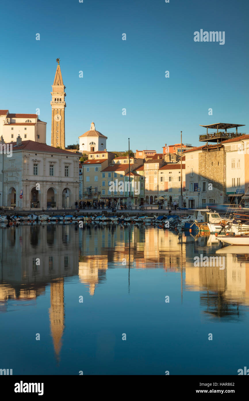 La lumière du soleil du soir sur la Marina, flèche de l'église paroissiale de Saint Georges et du centre-ville (Tartinijev trg), Piran, Slovénie Primorska, Banque D'Images