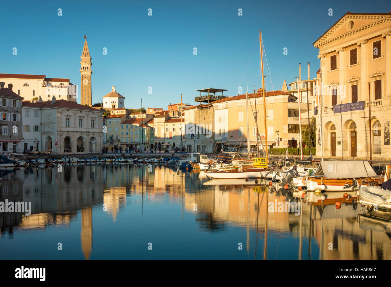 La lumière du soleil du soir sur la Marina, flèche de l'église paroissiale de Saint Georges et du centre-ville (Tartinijev trg), Piran, Slovénie Primorska, Banque D'Images