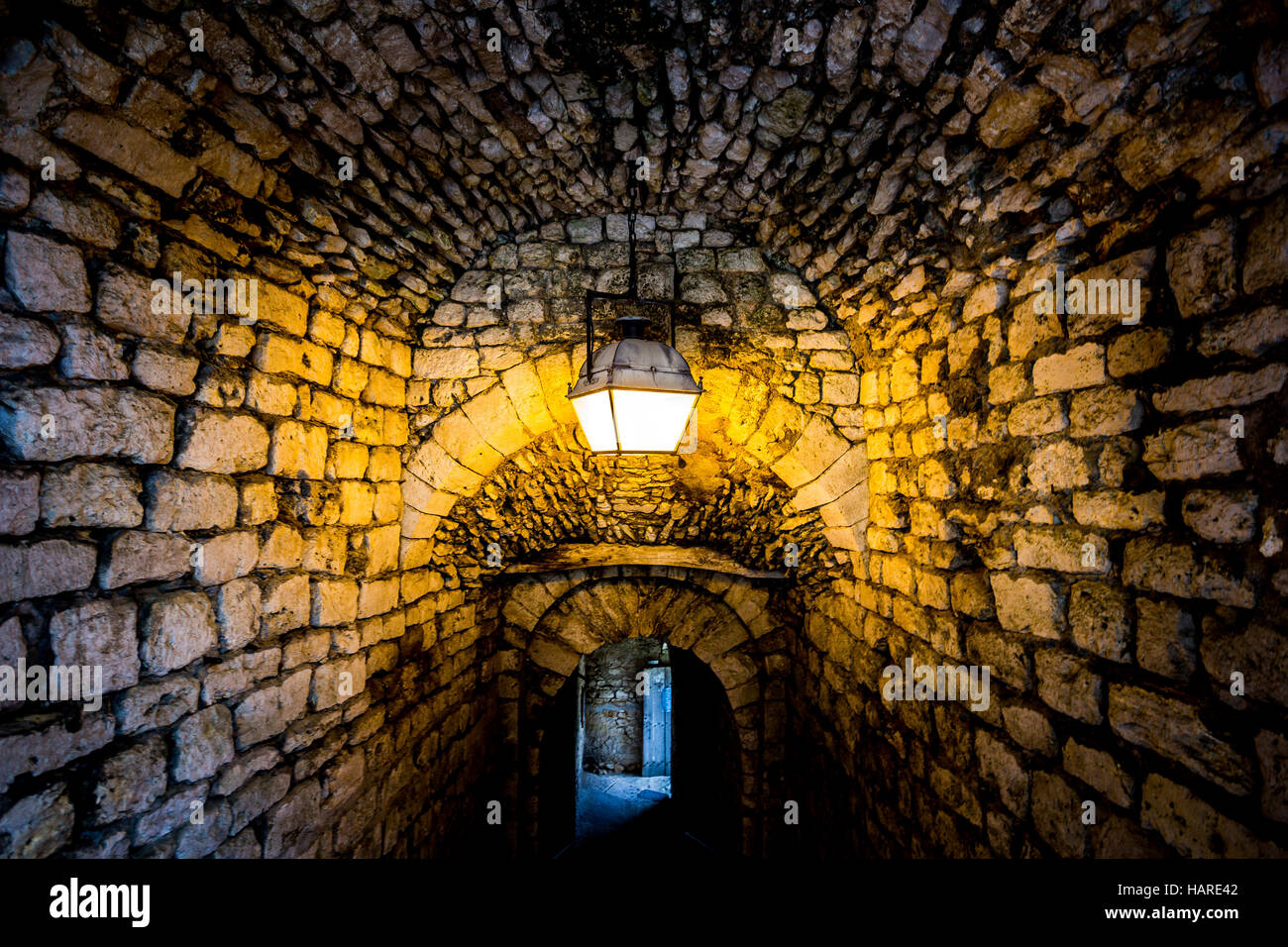 Ancien passage de pierre éclairé par une seule lampe Banque D'Images