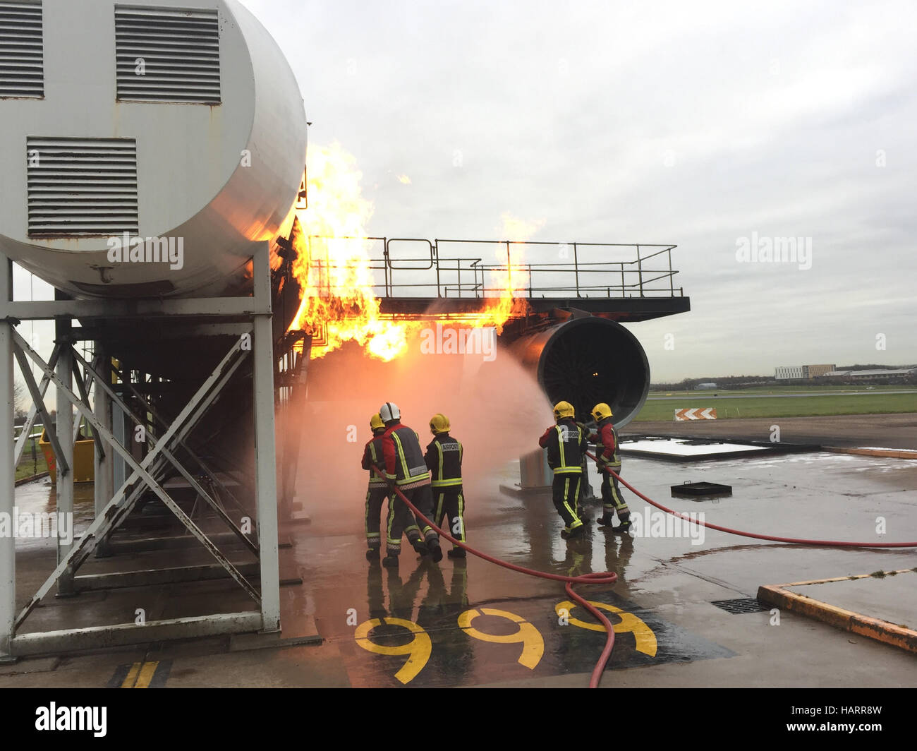 D'incendie et de secours de l'aéroport train sur un incendie simulé sur une aile d'avion à l'aéroport de East Midlands au Royaume-Uni. Banque D'Images