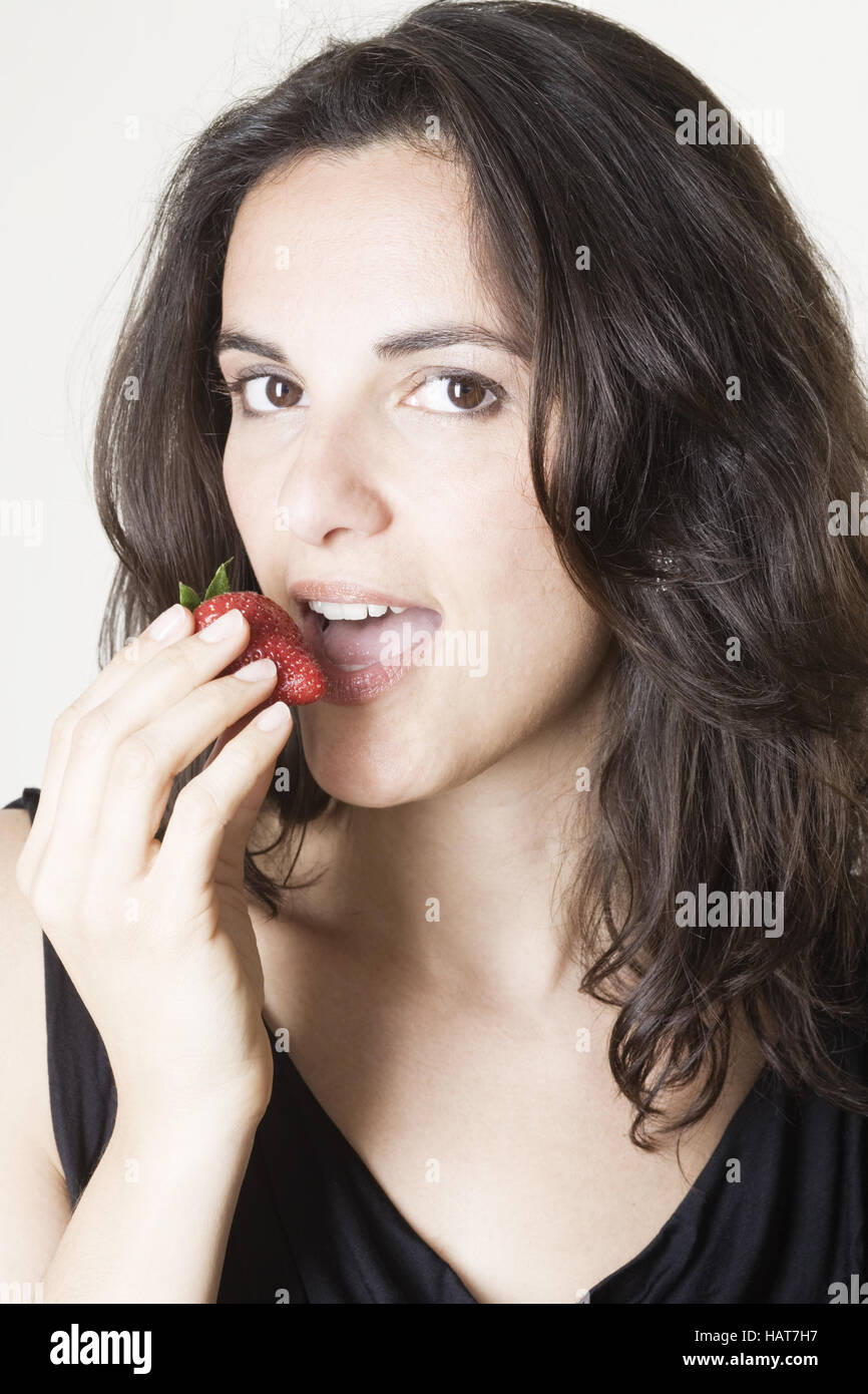 Femme mangeant une fraise rouge Banque D'Images