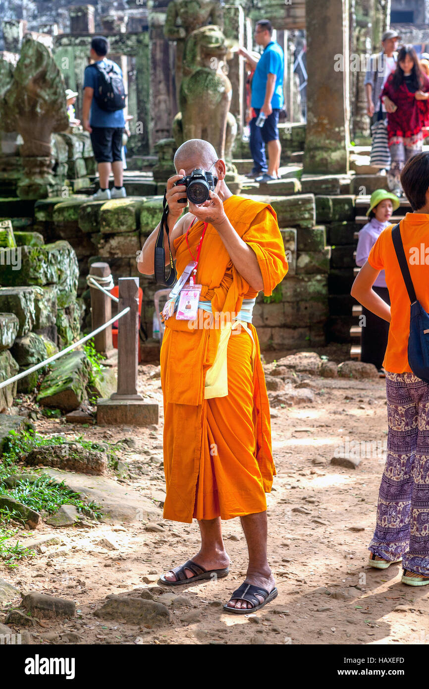 Un moine bouddhiste tournée prend des photos dans l'ancien temple du complexe d'Angkor Thom à Siem Reap, Royaume du Cambodge. Banque D'Images