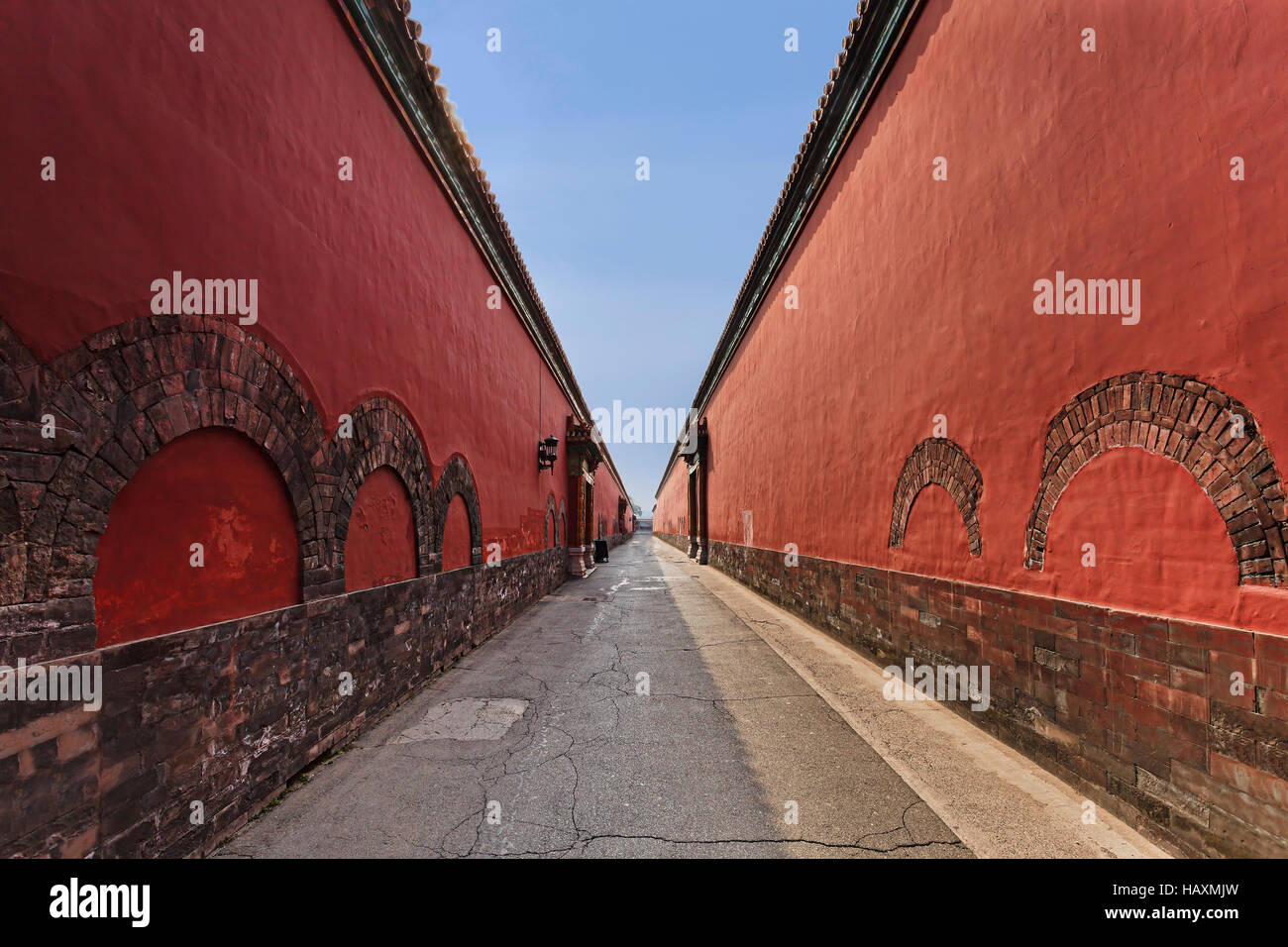 Passage étroit entre de hauts murs de brique rouge dans la Cité interdite des empereurs chinois entourant la résidence des empereurs des dynasties d'autre monde. Banque D'Images