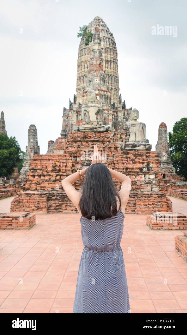 Fille priant devant Bouddha à Ayutthaya, Thaïlande Banque D'Images