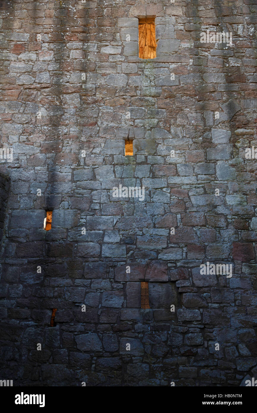 Mur de château Crichton avec des meurtrières et des fenêtres éclairées par sublight en fin d'après-midi, en Écosse. Banque D'Images