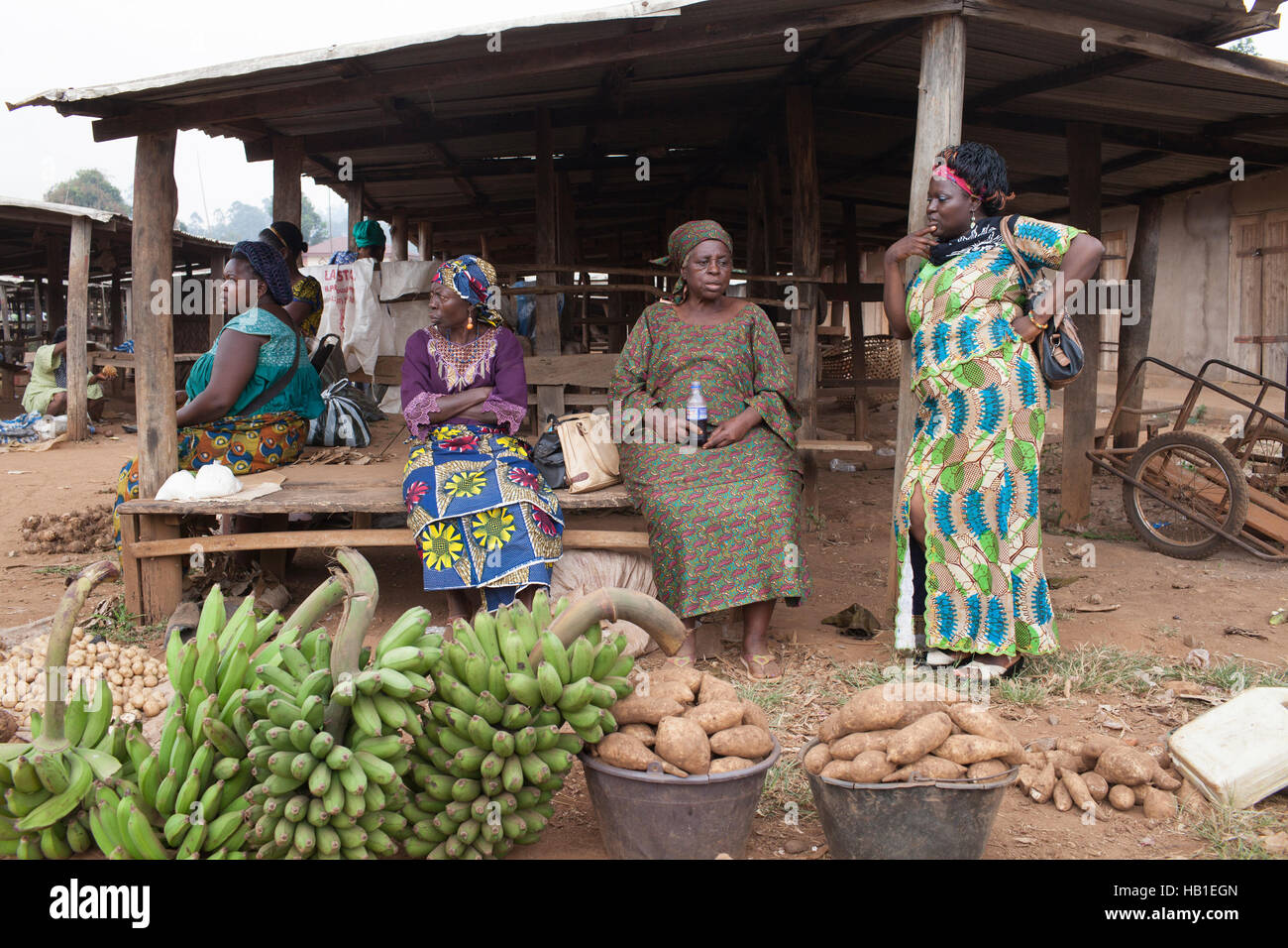 Les Noires ou ethniques en vêtements traditionnels de l'Afrique de l'ouest rural market stall Banque D'Images