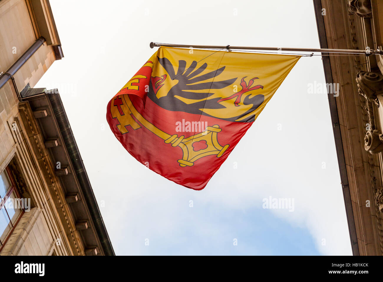 La ville de Genève, Suisse. Avec armoiries drapeau monté sur mur ancien bâtiment montrant l'aigle impérial et une clef de Saint-Pierre Banque D'Images