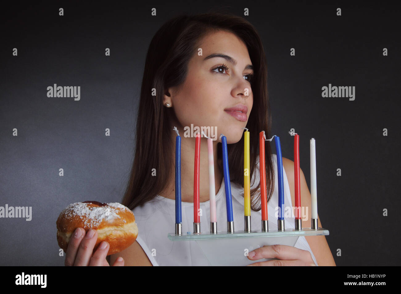 Hanouka -belle femme avec de la confiture et des bougies donut Banque D'Images