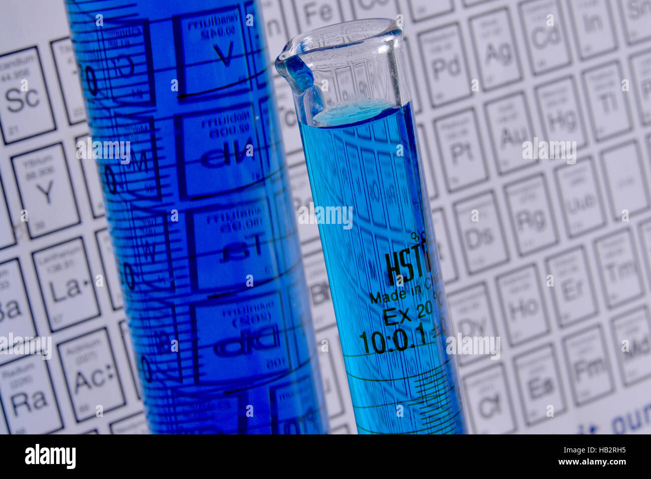 Bleu avec cylindres gradués, chimie tableau périodique en arrière-plan Banque D'Images