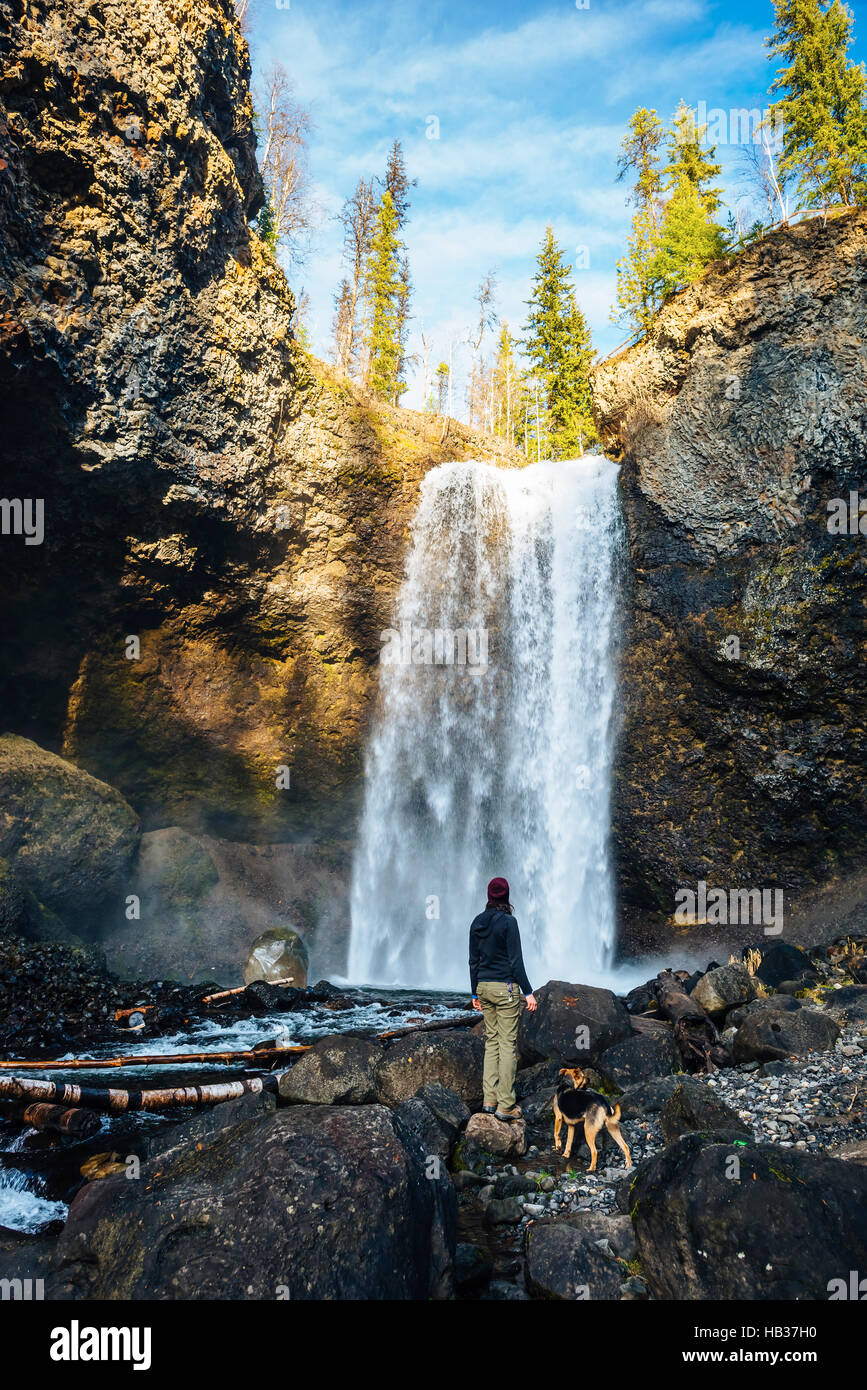 Une jeune femme et son chien admirer Moul Falls dans le parc provincial Wells Gray, British Columbia, Canada Banque D'Images