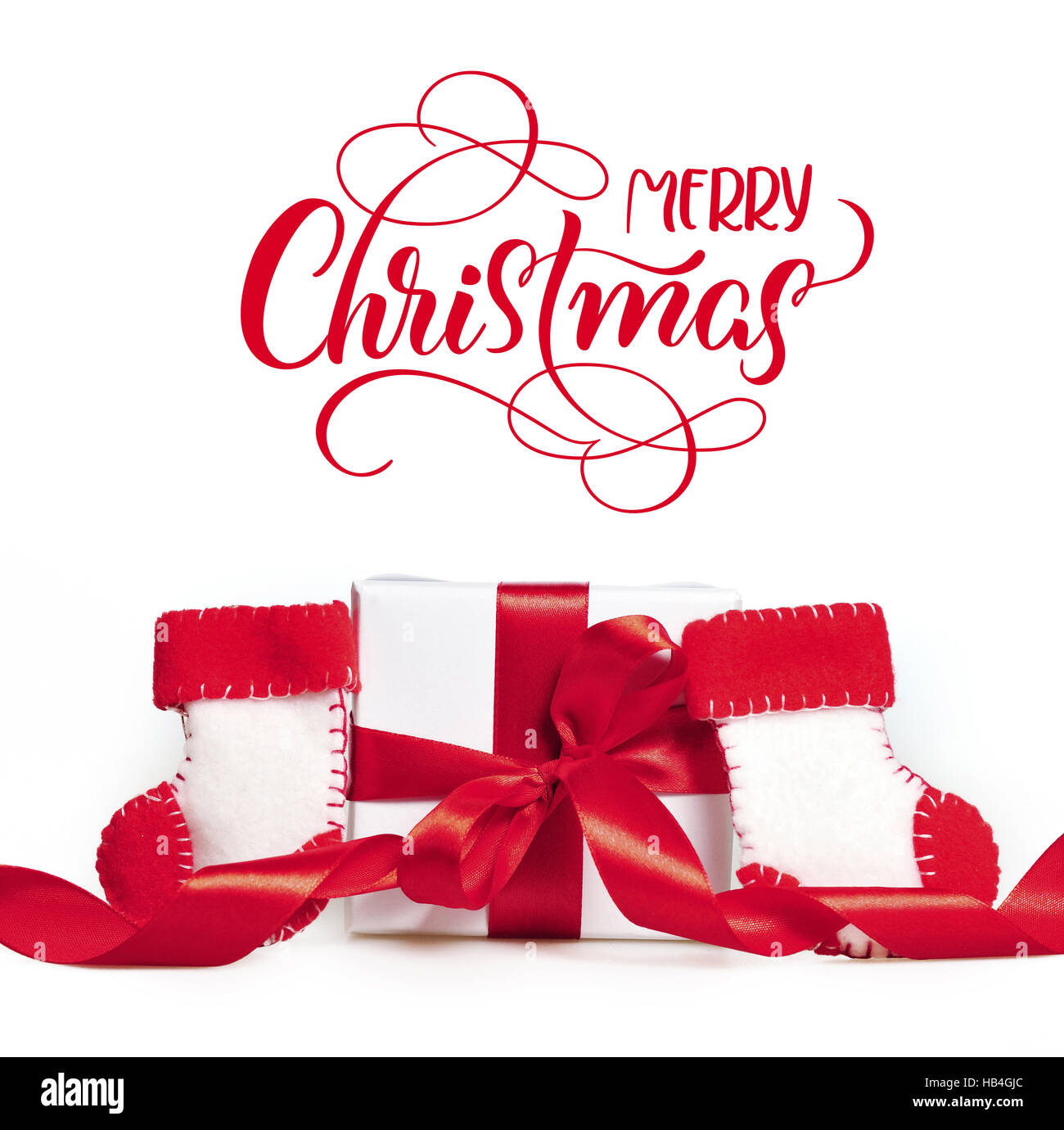 Des rubans rouges et des bottes cadeaux du Père Noël avec texte Joyeux Noël. Calligraphie lettrage Banque D'Images