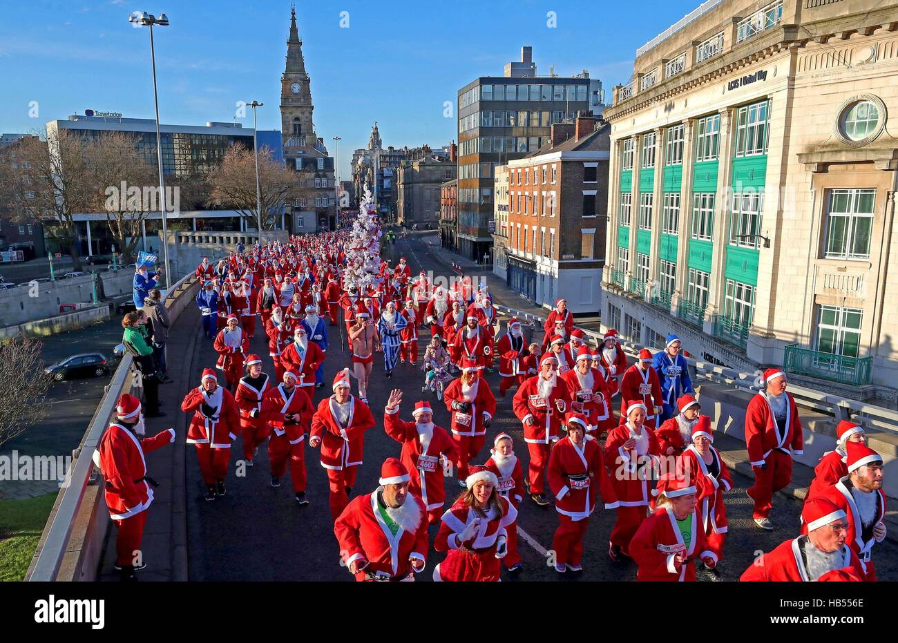 Porteur habillé en père Noël font leur chemin autour d'un cours de 5k au Radio City Liverpool Santa Dash, afin de recueillir des fonds pour la trésorerie du Radio City, Everton pour les enfants dans la Communauté et Zoe's Place Soins de bébé. Banque D'Images