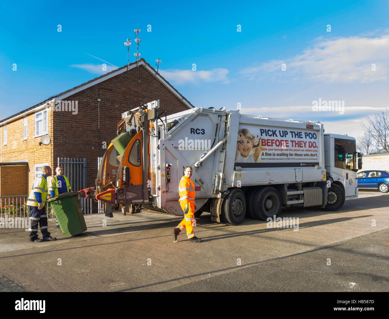 Les hommes qui travaillent à l'arrière d'un véhicule d'élimination des déchets vidange d'un wheelie bin de déchets ménagers pour le recyclage pick up dog poo Banque D'Images