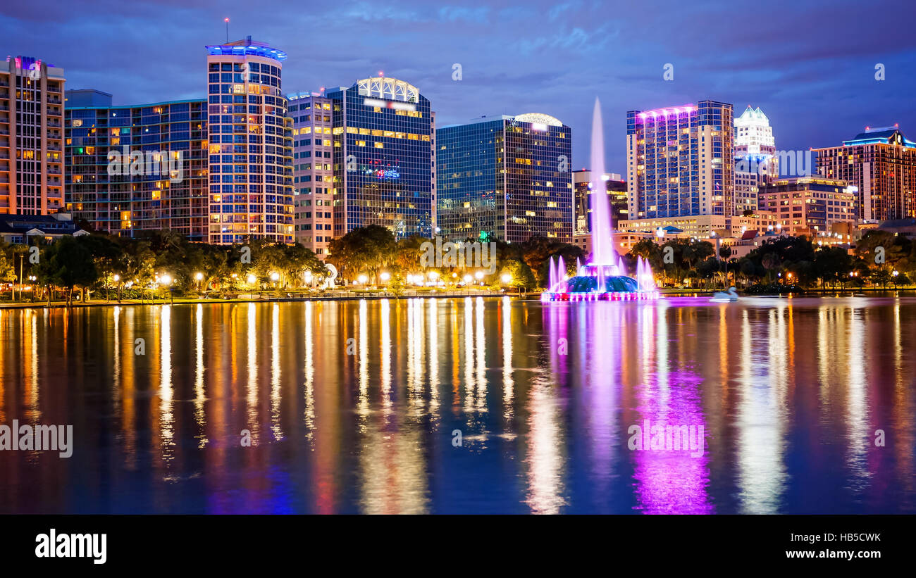 Orlando, Floride sur les toits de la ville et de l'eau Fontaine à la nuit dans le lac Eola Park, bâtiment à usage commercial floue logos) Banque D'Images