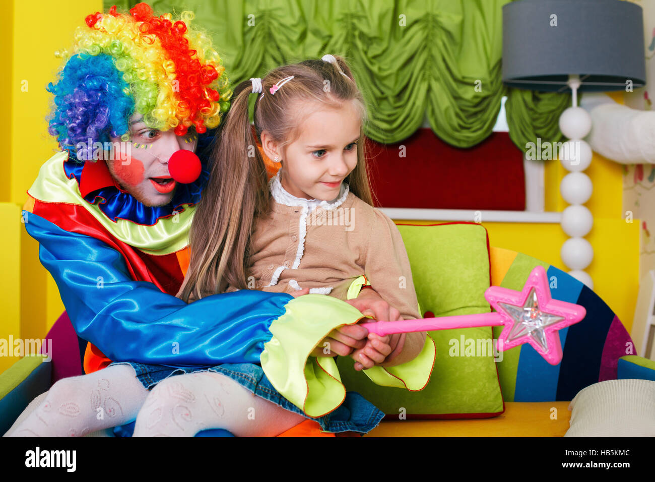 Fille jouant avec clown joyeux Banque D'Images