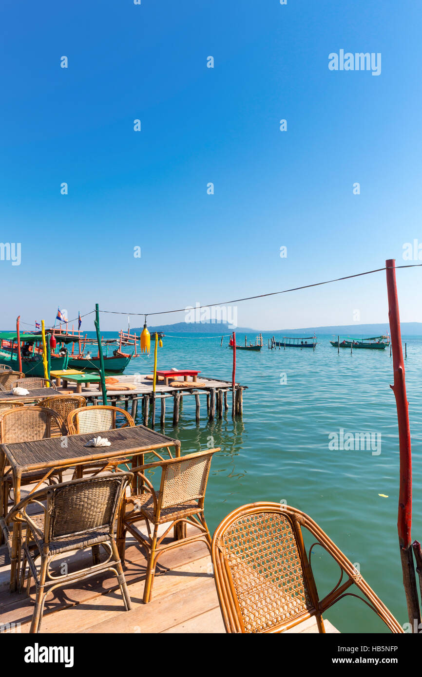 Port de Koh Rong avec table et chaises vides sur la jetée. Cambodge Banque D'Images