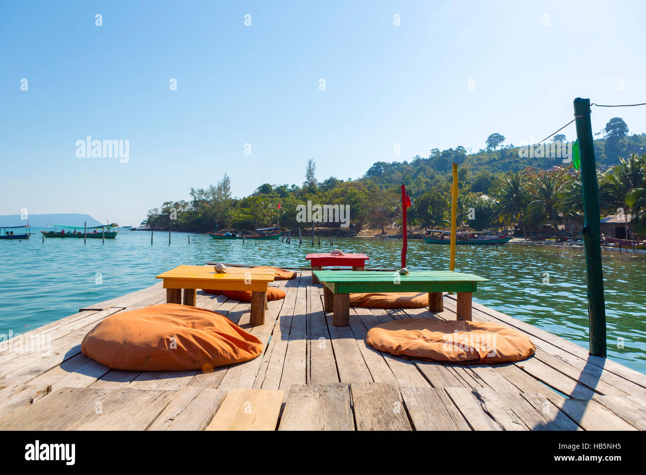 Port de Koh Rong avec table et chaises vides sur la jetée. Cambodge Banque D'Images