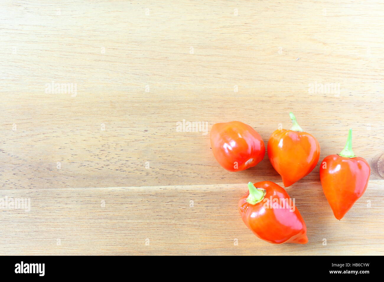 Chili Peppers ghost orange sur une planche en bois Banque D'Images