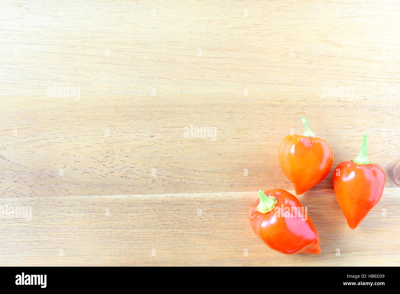 Chili Peppers ghost orange sur une planche en bois Banque D'Images