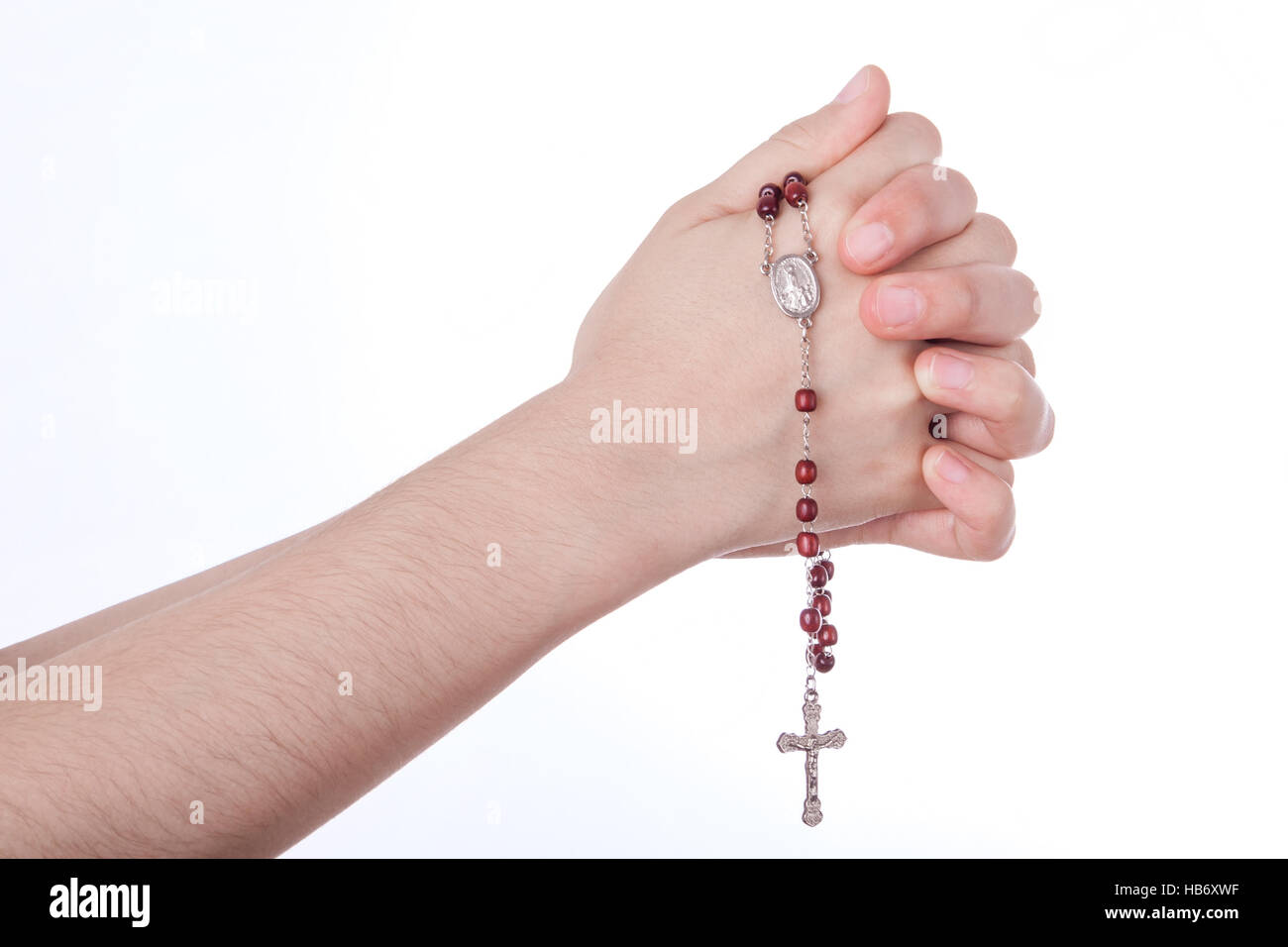 Les mains en prière fermé tenant un rosaire isolé sur fond blanc Banque D'Images