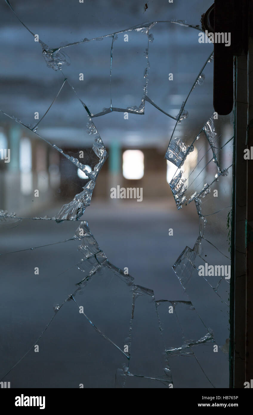 Du verre brisé dans fenêtre sur chambre vide Banque D'Images