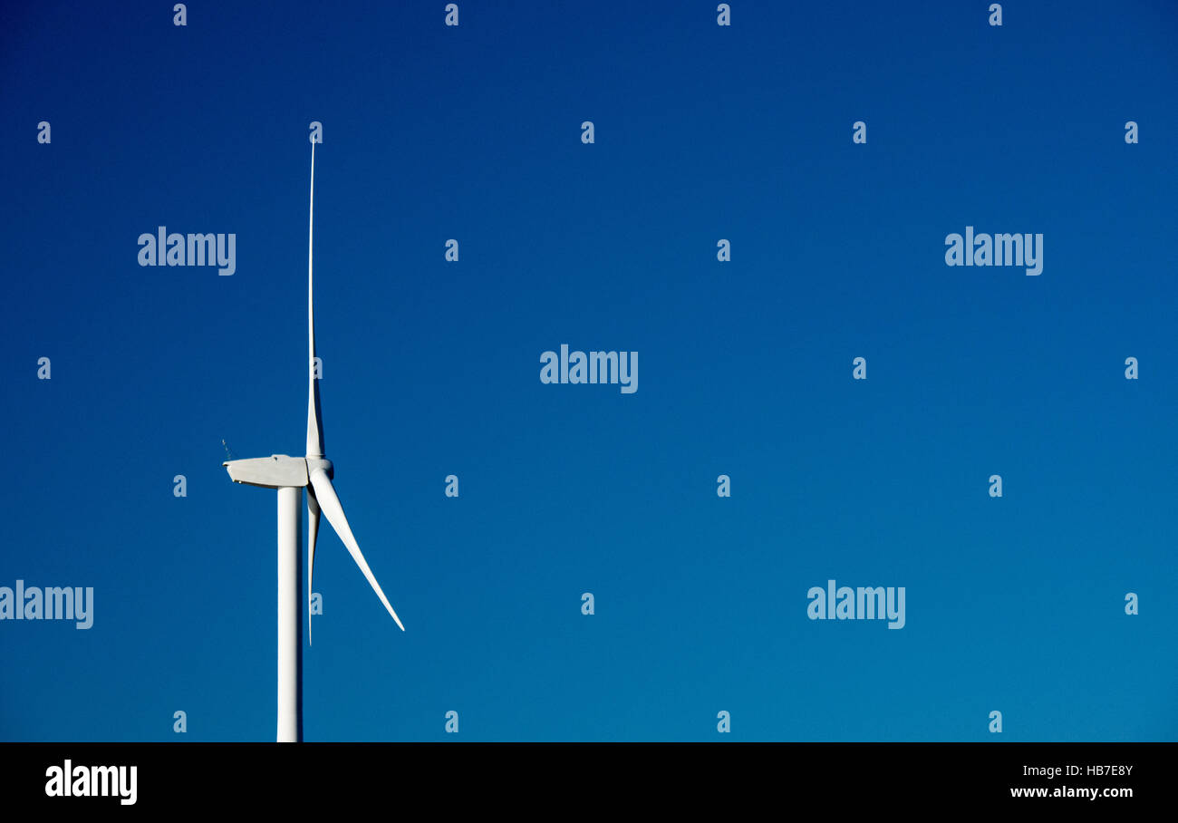 Les aubes de turbine de vent tourné le dos contre un blanc lumineux parfait bleu ciel d'été Banque D'Images