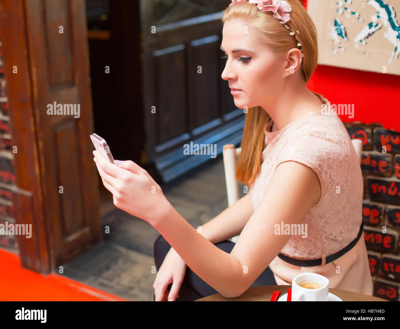 Femme blonde en utilisant son mobile à l'envoi de sms. Banque D'Images