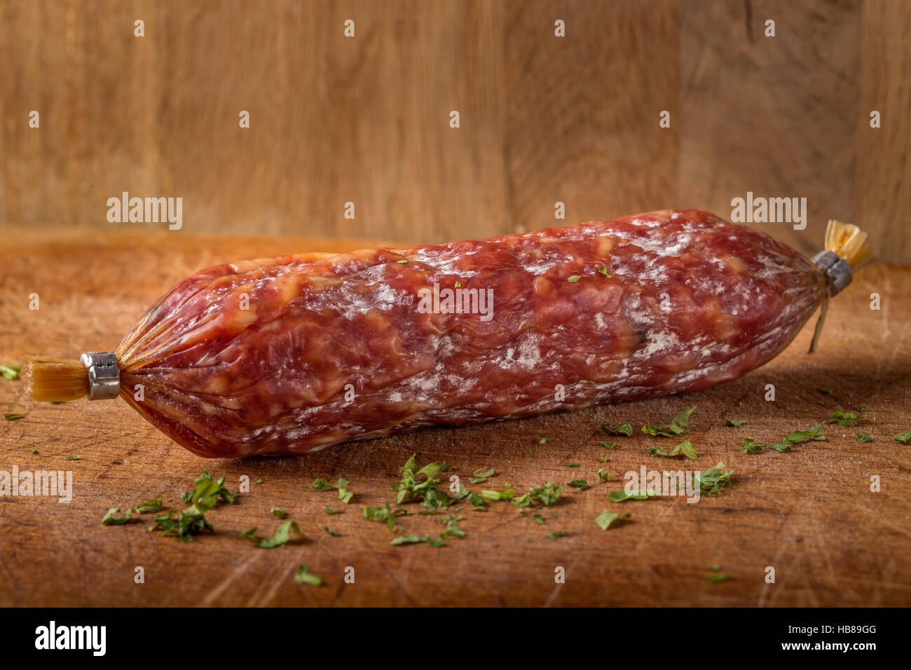 Salami italien sur planche à découper en bois, sur fond de bois Banque D'Images