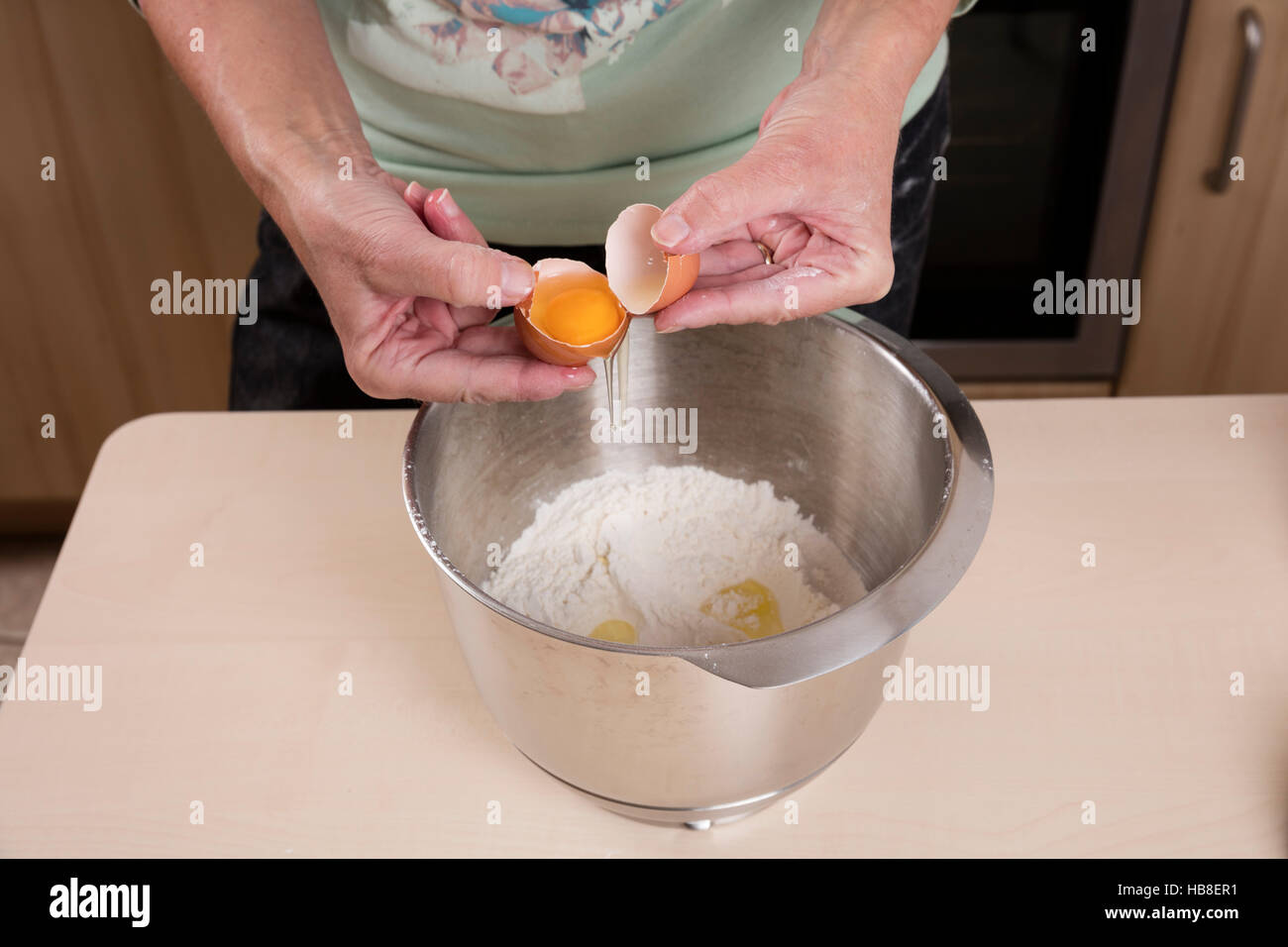 Femme met l'oeuf dans bol de pâte, la préparation Cuisson Banque D'Images