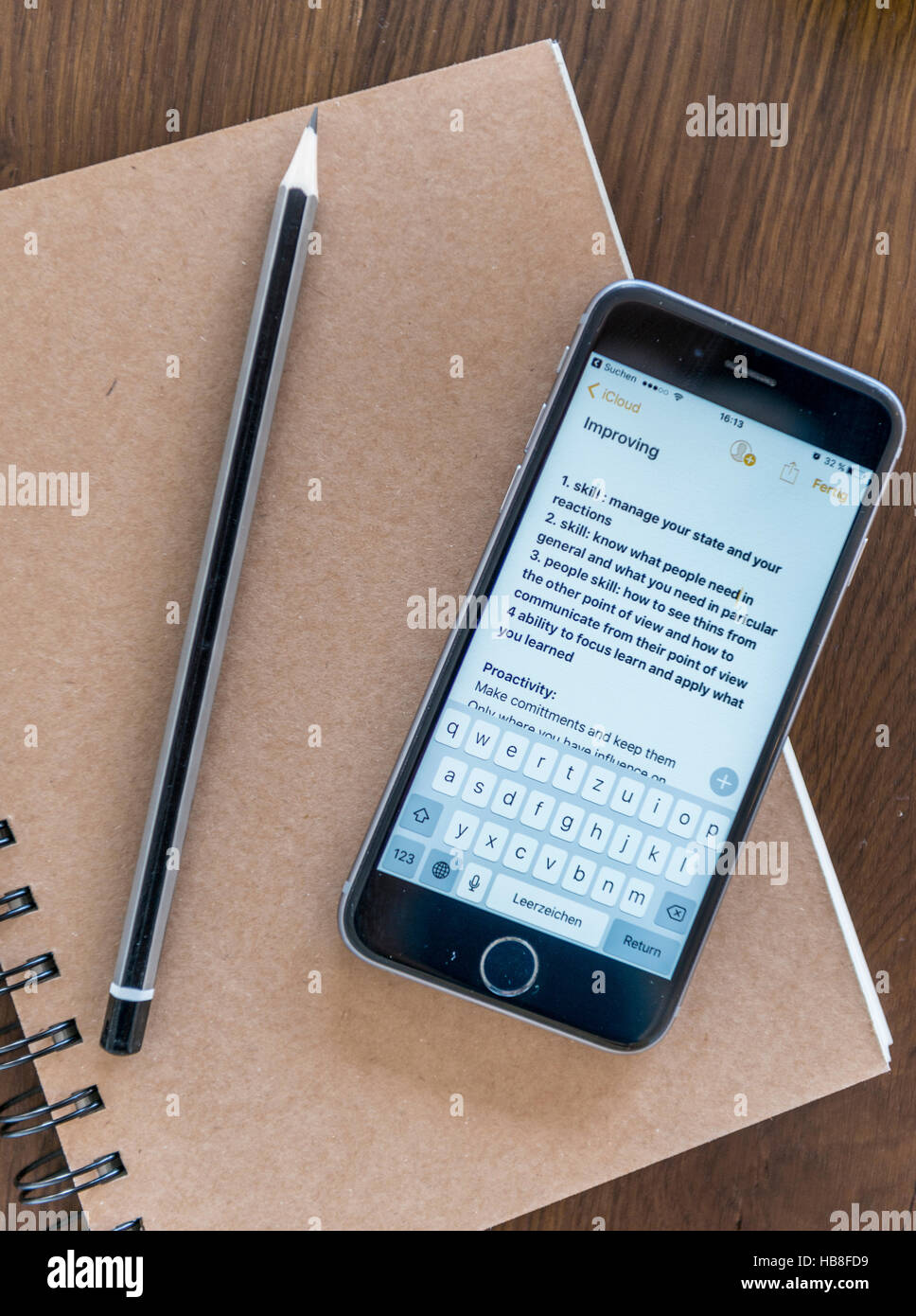 Notes sur smartphone, carnet et un stylo sur une table en bois Banque D'Images