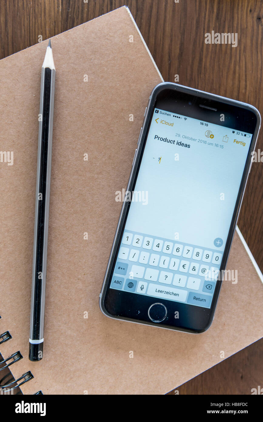 Idées de produits saisis sur l'écran du smartphone, carnet et un stylo sur une table en bois Banque D'Images