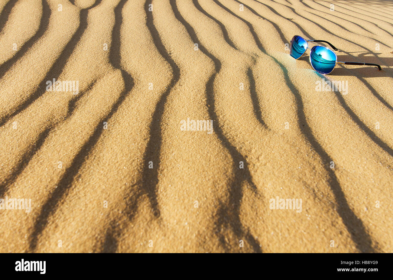 Lunettes de soleil sur le sable dans le désert. Banque D'Images