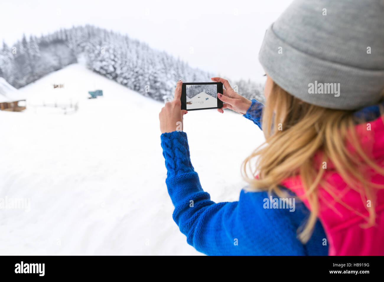 Girl Taking photo sur Smart Phone montagne jeune femme hiver neige Banque D'Images